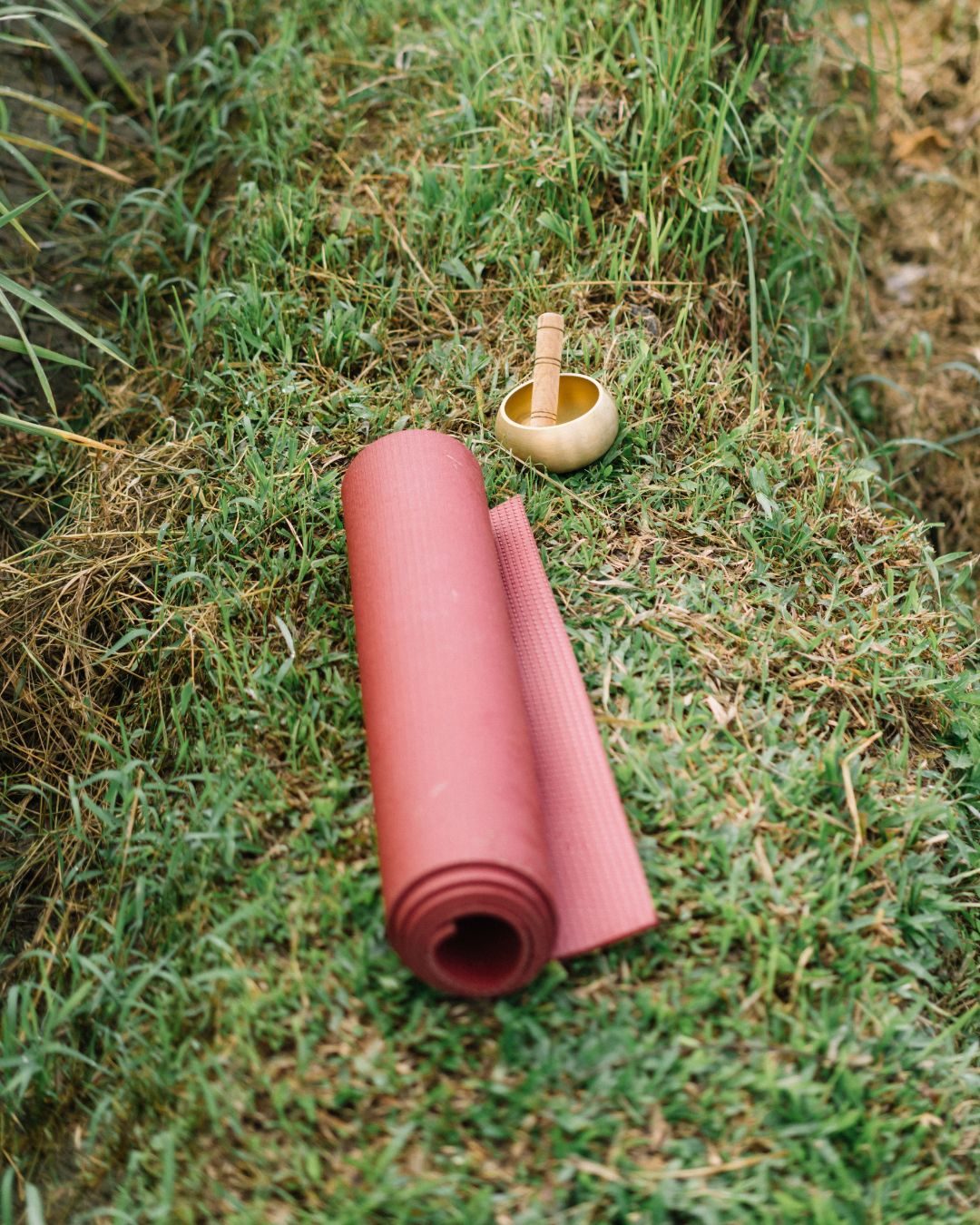 A mat and singing bowl set out on grass