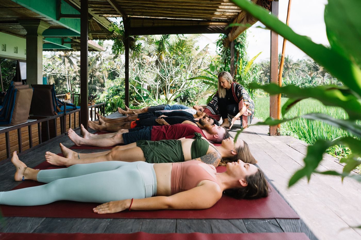 A Reiki training session with participants lying on mats outdoors
